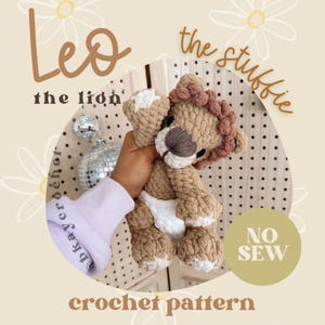 Op de afbeelding: Een gehaakt leeuwenknuffel in tinten bruin, beige en wit. De leeuw heeft een pluizige manen en een witte luier. Tekst op de afbeelding luidt "Leo the lion" en "crochet pattern".