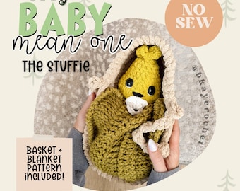 Könnte beinhalten: Ein gelbes und olivgrünes Häkel-Stofftier, eingewickelt in eine beige Decke. Der Text lautet: itty BABY mean one THE STUFFIE, NO SEW, BASKET + BLANKET PATTERN INCLUDED!, crochet pattern und @bkaycrochet. Das Stofftier hat schwarze Augen.