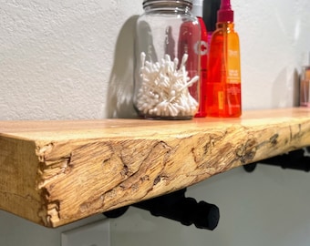 Wood slab floating shelf with iron pipe brackets