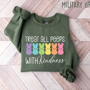 May include: A green sweatshirt with the text "Treat all peeps with kindness" and a row of colorful marshmallow peeps.