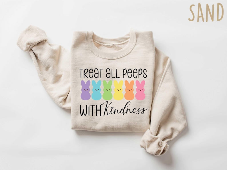 May include: A beige sweatshirt with the text "Treat all peeps with kindness" and a row of colorful marshmallow peeps.
