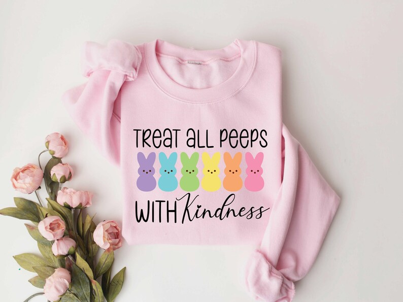 May include: Pink sweatshirt with a rainbow of Peeps and the text "Treat all peeps with kindness".