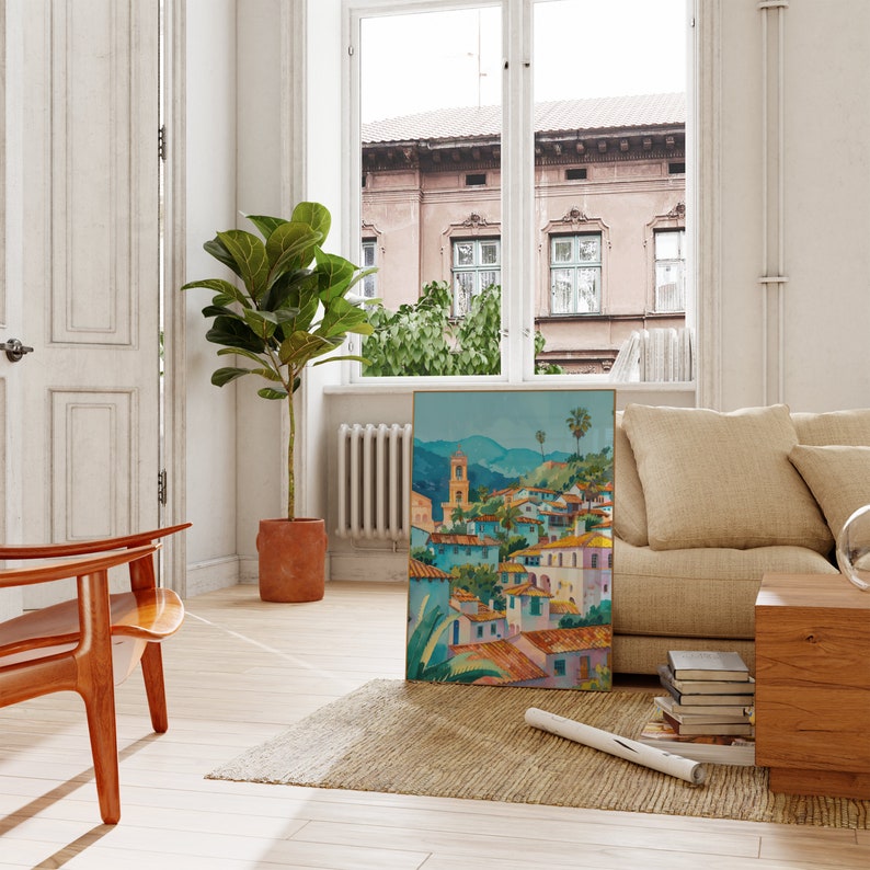May include: A framed painting of a colorful cityscape with a church steeple and palm trees. The painting is hanging on a white wall in a room with a wooden floor, a large window, and a couch.