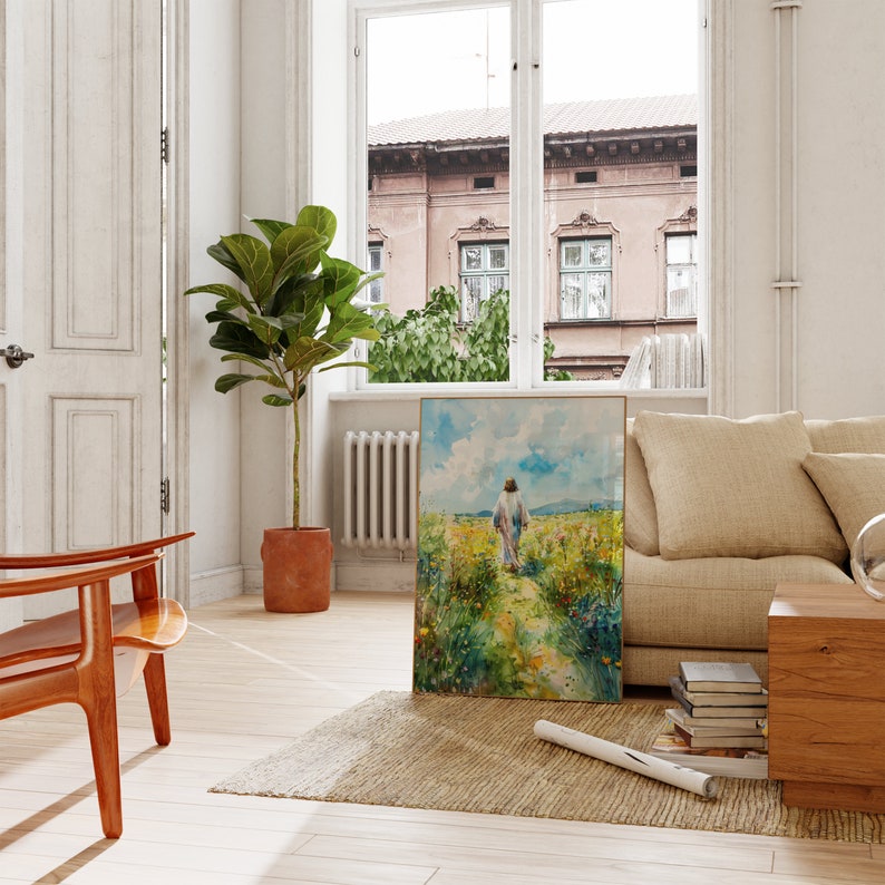 Puede incluir: Una pintura de una persona caminando por un sendero a trav&eacute;s de un campo de flores. La pintura est&aacute; enmarcada en un marco dorado y est&aacute; colgada en una pared blanca. La pintura est&aacute; en una sala de estar con un sof&aacute; y una silla.