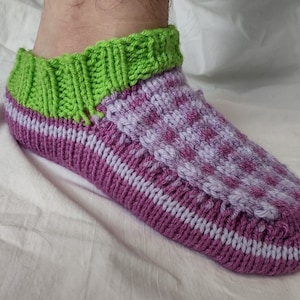 Könnte beinhalten: Lila und grüne gestrickte Socken mit einem karierten Muster. Die Socken sind aus weichem Garn gefertigt und haben eine bequeme Passform.