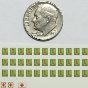 以下が含まれることがあります： 緑と赤の数字「1」のデカールが30枚と、赤いプラス記号が5枚のモデルデカールシート。デカールは、日本の10円玉と同じくらいの大きさです。