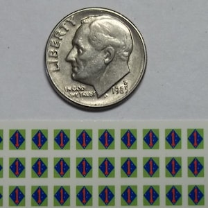 May include: A sheet of 36 stickers featuring the 1st Marine Division insignia. Each sticker is a green diamond with a blue diamond inside, containing a red number "1" and a white star. The stickers are approximately the size of a dime.