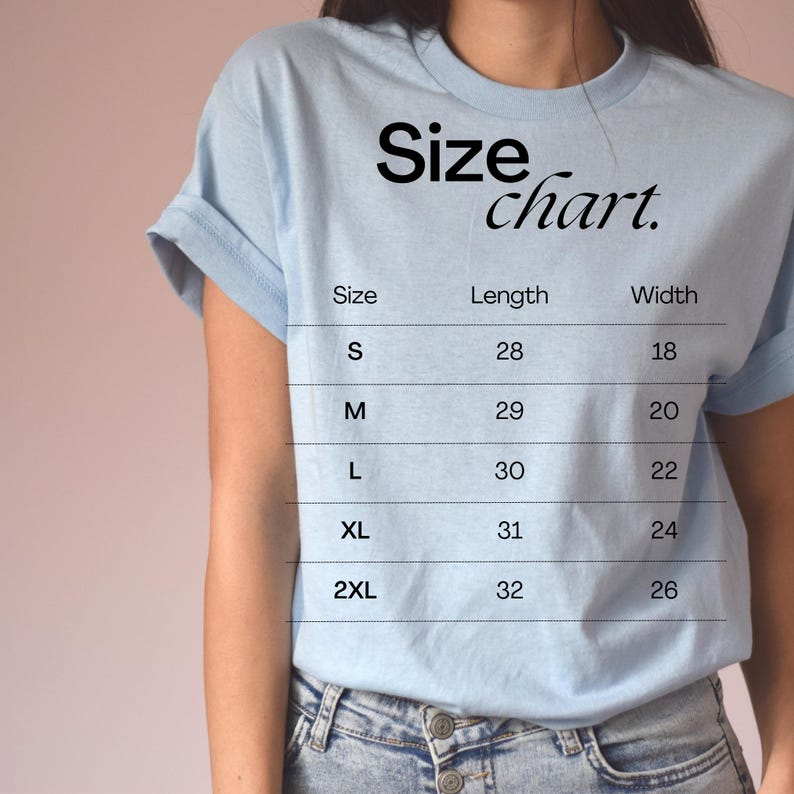 Puede incluir: Una camiseta azul claro con una tabla de tallas impresa en la parte delantera. La tabla muestra la talla, la longitud en pulgadas y el ancho en pulgadas para las tallas S, M, L, XL y 2XL.