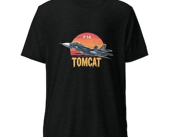 May include: Dark grey t-shirt with a graphic of an F-14 Tomcat fighter jet against a sunset. The text "F-14" is above the jet, and "TOMCAT" is below. The design is centered on the shirt.