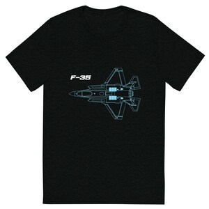 May include: Black t-shirt featuring a light blue schematic of an F-35 fighter jet. The text "F-35" is printed in white above the jet illustration. The shirt is made of a soft, comfortable material.