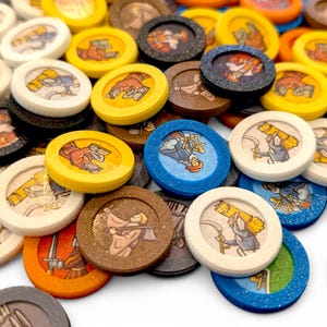 May include: A collection of colorful, circular game tokens. Each token features a unique illustration of medieval figures and objects, set against a variety of backgrounds. The tokens are in shades of yellow, brown, blue, and white, with a textured appearance.