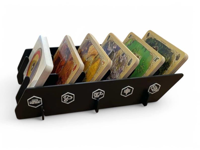 Puede incluir: Porta tarjetas negro con seis ranuras para guardar tarjetas. El porta tarjetas tiene un dise&ntilde;o hexagonal con un acento plateado. El porta tarjetas est&aacute; lleno de tarjetas con fondos de colores diferentes.