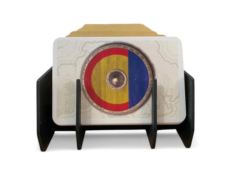 Puede incluir: Porta tarjetas negro con tres ranuras para tarjetas. El porta tarjetas est&aacute; hecho de madera y tiene un acabado negro. El porta tarjetas est&aacute; sosteniendo una tarjeta con un dise&ntilde;o de escudo. El escudo es amarillo, rojo y azul.