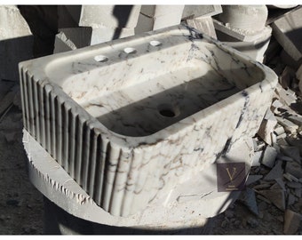 Pia de parede artesanal em mármore Calacatta Viola com furos espaçados para torneira.