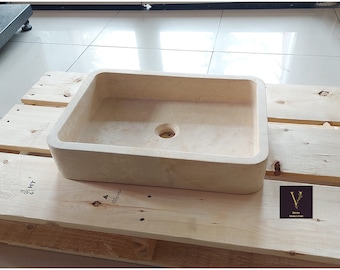 May include: A rectangular, off-white stone sink with a rounded edge. The sink is sitting on a wooden pallet.