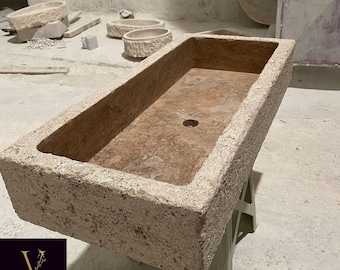 Pia artesanal com textura rústica em travertino escuro