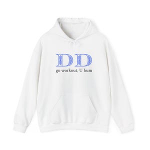 May include: A white hooded sweatshirt featuring a front kangaroo pocket and long sleeves. The chest displays two large blue capital letters D with a decorative snowflake-like pattern inside, followed by the black text go workout, U bum.