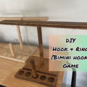 May include: DIY Hook and Ring (Bimini Hook) Game. A wooden game with two sets of hooks and rings. The game is made of wood and has a brown stain. The game is set up on a wooden table.