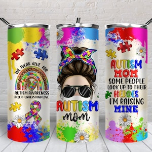 K&ouml;nnte beinhalten: Drei Edelstahlbecher mit bunten Designs und Text. Der erste Becher hat einen Regenbogen, Puzzle-Teile und den Text "We wear blue for Autism Awareness Accept Understand Love". Der zweite Becher hat eine Frau mit einem Dutt, Sonnenbrille und einer Gesichtsmaske und den Text "Autism Mom". Der dritte Becher hat Puzzle-Teile und den Text "Autism Mom Some people look up to their heroes I'm raising mine".