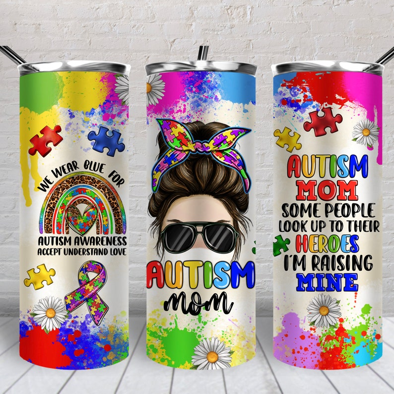 K&ouml;nnte beinhalten: Drei Edelstahlbecher mit bunten Designs und Text. Der erste Becher hat einen Regenbogen, Puzzle-Teile und den Text "We wear blue for Autism Awareness Accept Understand Love". Der zweite Becher hat eine Frau mit einem Dutt, Sonnenbrille und einer Gesichtsmaske und den Text "Autism Mom". Der dritte Becher hat Puzzle-Teile und den Text "Autism Mom Some people look up to their heroes I'm raising mine".