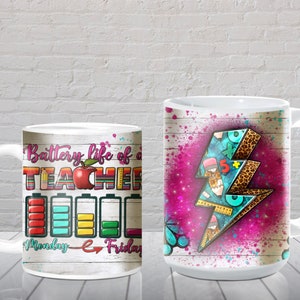 May include: Two white ceramic mugs with different designs. The mug on the left has a white background with a red apple and the text "Battery life of a teacher" and a row of battery icons labeled "Monday" to "Friday". The mug on the right has a pink and white background with a blue and white lightning bolt design with a leopard print pattern.