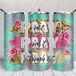 May include: A stainless steel tumbler with a teal, pink, and brown design. The tumbler features the words "Pray on it, Pray over it, Pray through it".