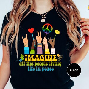 a woman wearing a t - shirt that says imagine all the people living life in