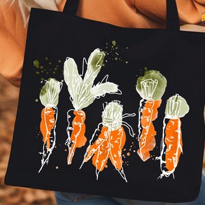 a woman holding a black bag with carrots painted on it
