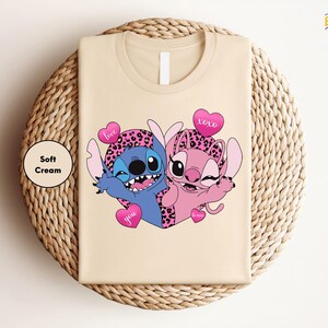 A t-shirt with a cartoon image of two cartoon characters, one blue and one pink, along with hearts and the text "Love you".