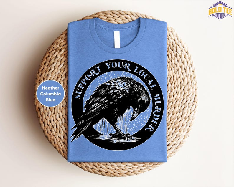 a blue t - shirt with a black bird on it