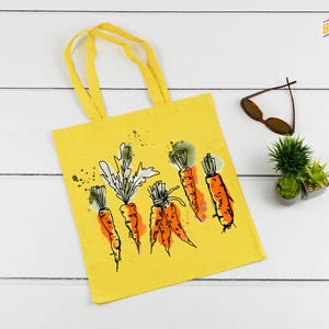 a yellow tote bag with carrots drawn on it
