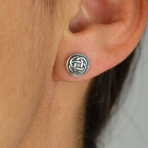 May include: Silver Celtic knot stud earrings. The earrings are round and feature a detailed knot design.