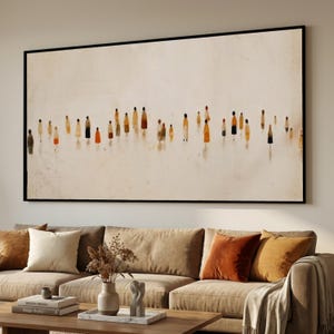 Könnte beinhalten: Großer gerahmter Kunstdruck mit einem minimalistischen Design von zahlreichen Figuren in verschiedenen Farben, darunter Gelb, Orange und Schwarz, vor einem neutralen Hintergrund. Das Kunstwerk wird über einem beigen Sofa mit dekorativen Kissen ausgestellt.