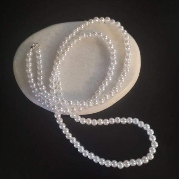 Colliers fausses perles blanches de 80 cm.