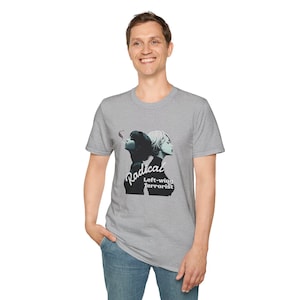 May include: A light gray t-shirt featuring a graphic of two women in profile with the word "Radical" in a stylized script and the words "Left-wing Terrorist" below. The shirt is made of a soft material.