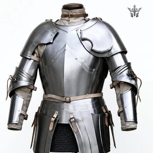 Könnte beinhalten: Ein polierter Brustpanzer und Armpanzer aus Stahl, Teil einer mittelalterlichen Rüstung. Die Rüstung verfügt über bewegliche Platten, Lederriemen und Nieten. Das Design umfasst Schulterpanzer und einen Taillengürtel, der historische Handwerkskunst zeigt.