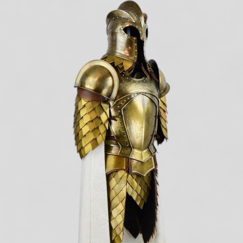 Op de afbeelding: Een volledig goudkleurig harnas, inclusief helm, borstplaat en schouderbeschermers. Het harnas heeft ingewikkelde details en een gelaagd ontwerp op de schouders en onderlichaam. Een witte stof hangt van het harnas.