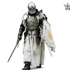 May include: A full suit of medieval armor, including a helmet, breastplate, and leg guards. The armor is silver-colored with intricate detailing. The knight is holding a long sword and a shield with a gold emblem. The knight is wearing white robes and black boots.