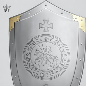 May include: A silver-colored shield with a cross emblem and gold corner accents. The shield features a circular emblem with a knight on horseback and the inscription "SIGILLVM MILITVM XPISTI". Rivets secure the shield's edges.