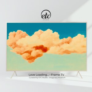 May include: A rectangular frame TV with a light beige frame and legs. The screen displays a painting of orange and yellow clouds against a blue sky. The text "Love Loading... Frame TV" is at the bottom.