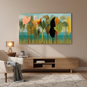 May include: A framed art print depicting a stylized landscape with colorful trees and foliage. The artwork features a variety of hues, including orange, green, yellow, and black, set against a light blue background. The print is displayed above a wooden media console.