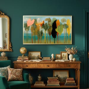 May include: A framed art print depicting stylized trees with colorful foliage, including orange, green, and yellow leaves. The artwork hangs above a wooden console table with books, framed pictures, and a globe. The room has teal walls and a gold-framed mirror.