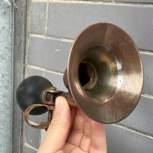 Puede incluir: Claxon de bicicleta vintage de lat&oacute;n con una pera de goma negra. El claxon tiene forma de campana acampanada y una abrazadera para sujetarlo a una bicicleta. El lat&oacute;n tiene una p&aacute;tina c&aacute;lida y envejecida. Un accesorio cl&aacute;sico para bicicletas vintage.