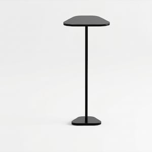Puede incluir: Una mesa auxiliar alta de color negro con un tablero triangular redondeado y liso, sostenido por un único poste vertical delgado que se conecta a una base triangular redondeada más pequeña, creando una estructura equilibrada.