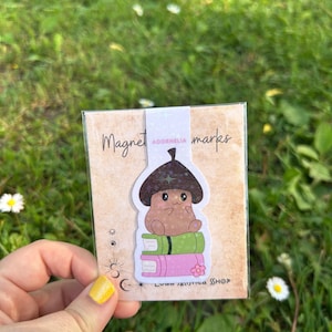 Marcapáginas de la Colección Acornelia. Separador con imán de bellota sobre libros. Regalo ideal de lectura.