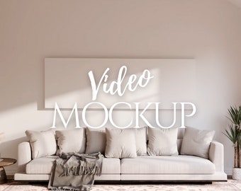 May include: A white couch with pillows and a throw blanket in a living room setting. A large white frame with the text "Video Mockup" is hanging on the wall above the couch.