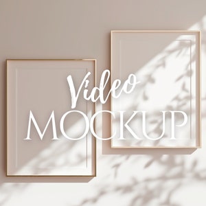 Könnte beinhalten: Zwei goldene Bilderrahmen an einer hellbeigen Wand mit dem Text "Video Mockup" in weißer Kursivschrift.