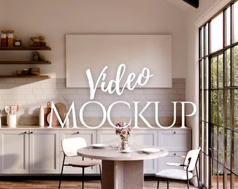 May include: A white framed video mockup in a modern kitchen with white cabinets, a wooden table, and two chairs. The kitchen has a large window with a view of green trees.
