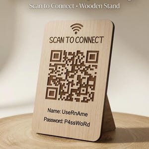 May include: A light-coloured wooden WiFi QR code sign measuring 8cm x 13cm, featuring a laser-engraved WiFi symbol, the text SCAN TO CONNECT, a QR code, and fields for Name: UseRnAme and Password: P4ssWoRd, supported by a matching wooden stand.