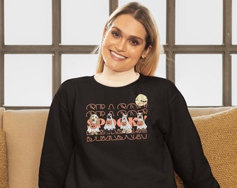 May include: Black sweatshirt with the text "SEASON SPOOKY SEASON" in orange. The graphic features four dogs dressed in Halloween costumes, including ghosts and holding jack-o'-lanterns. A full moon is in the upper right corner.